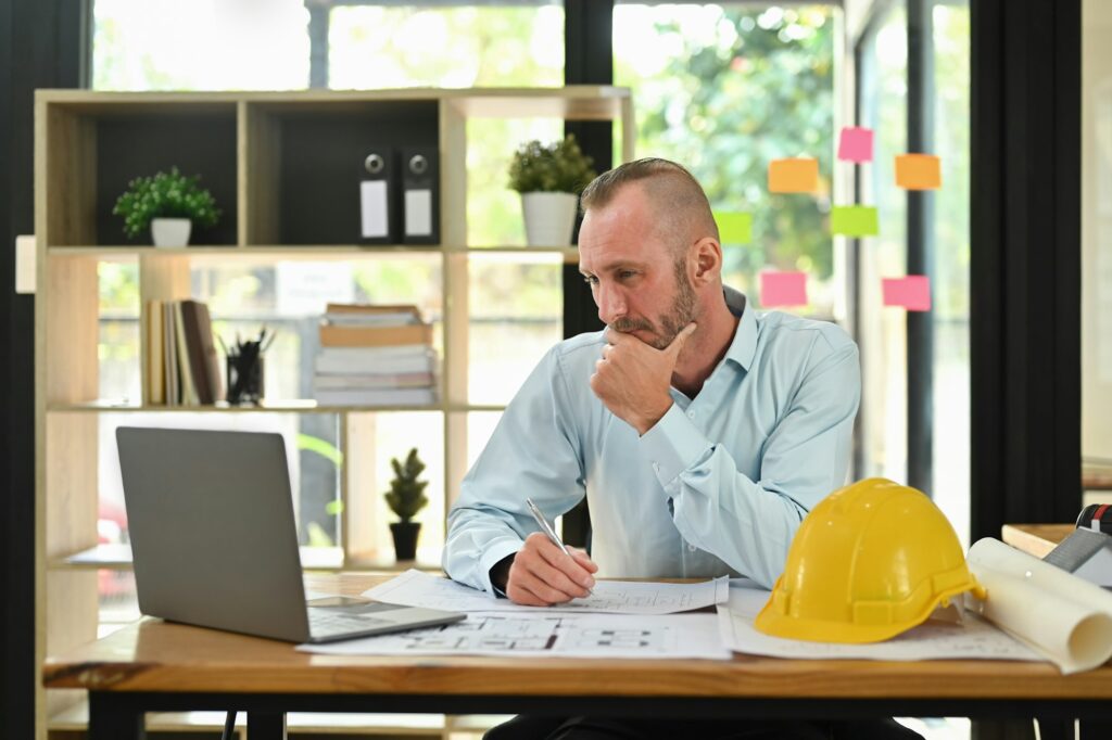 Focused engineer man having virtual meeting video conference on laptop.