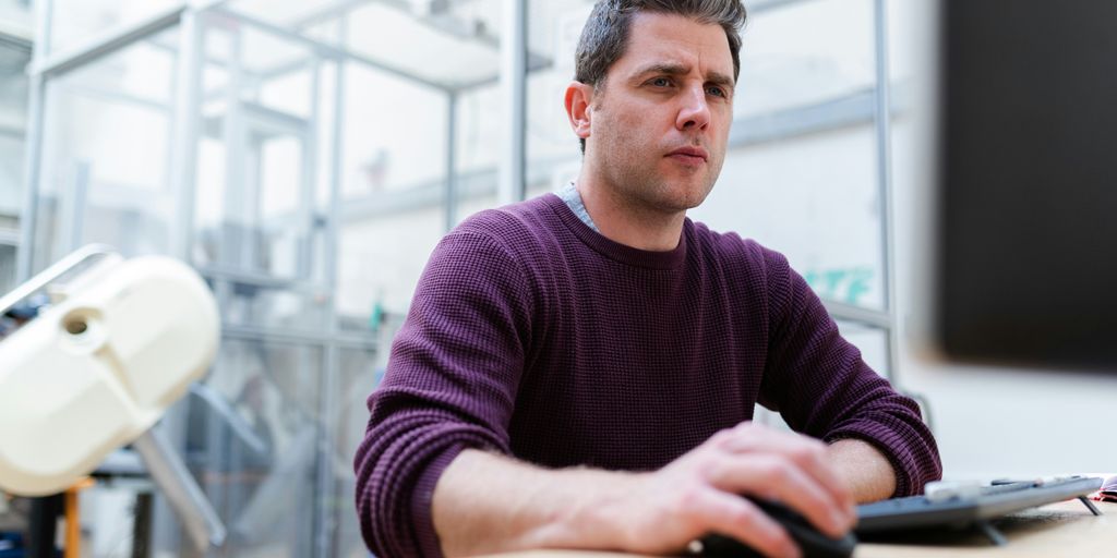 man in purple sweater sitting at the table